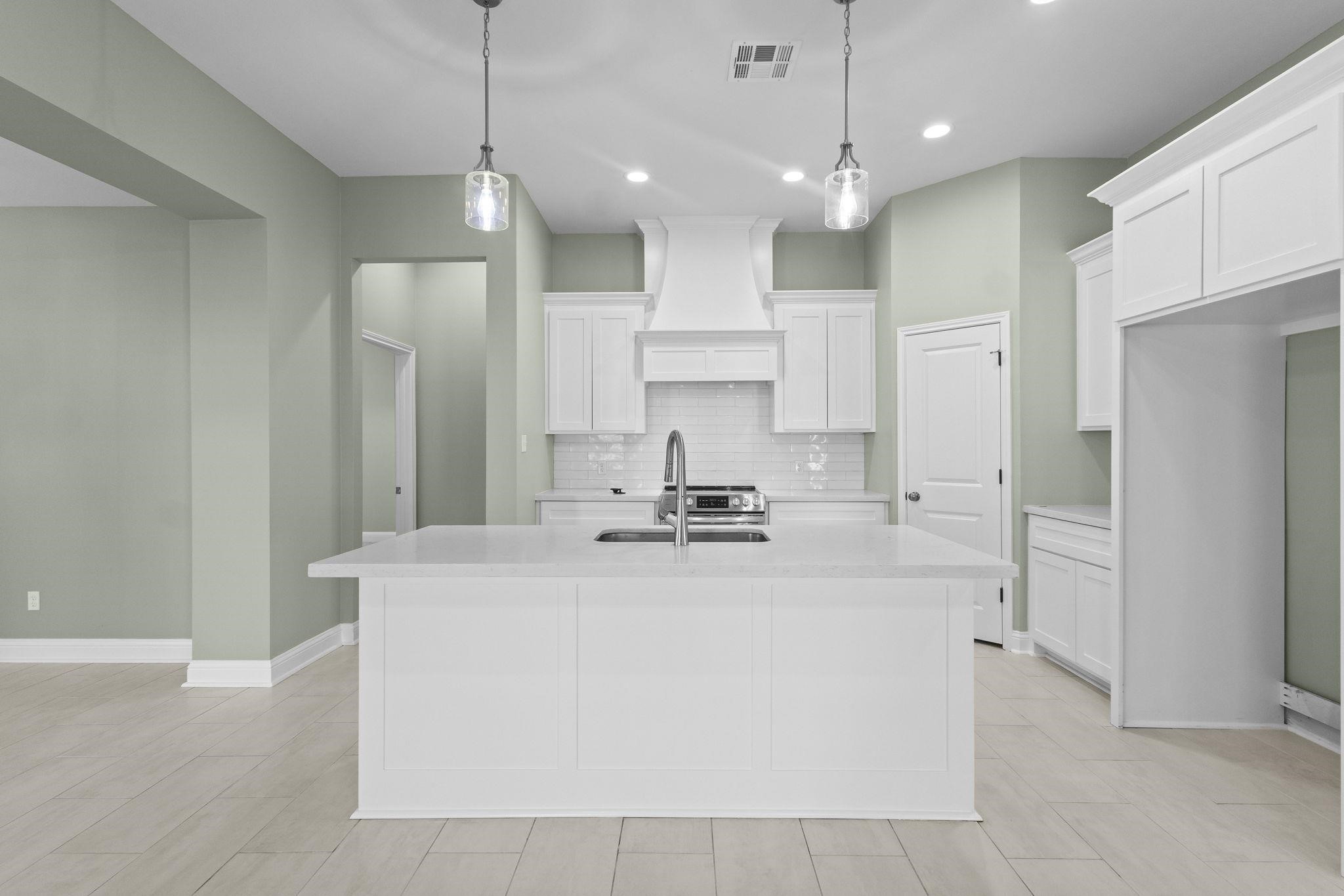 790 Bridgeview Street Bridge City, TX 77611 - Photo 6 of 31 a large kitchen with stainless steel appliances a large counter top a stove a refrigerator and a sink