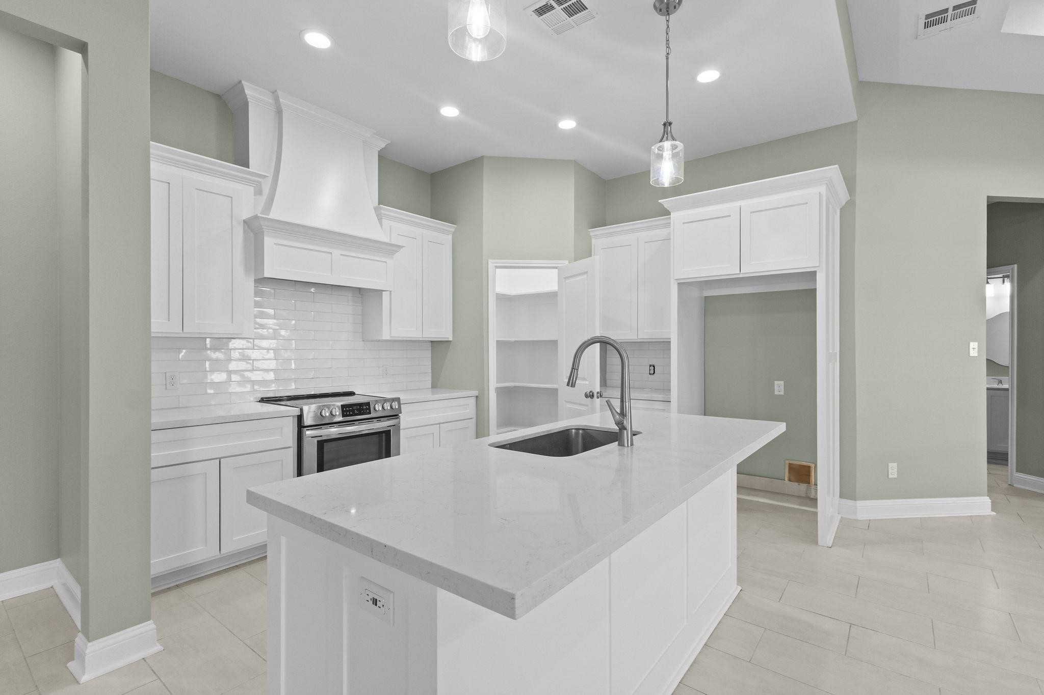 790 Bridgeview Street Bridge City, TX 77611 - Photo 10 of 31 a kitchen with kitchen island a sink stainless steel appliances and cabinets