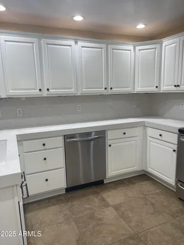 a kitchen with white cabinets and white appliances