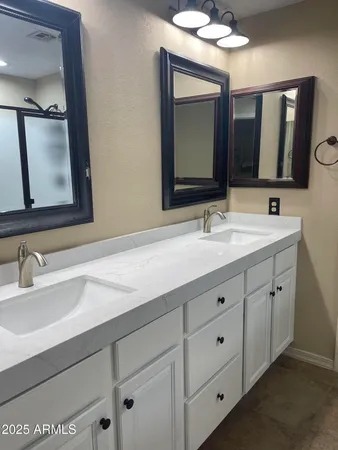 a bathroom with double vanity sinks and a mirror