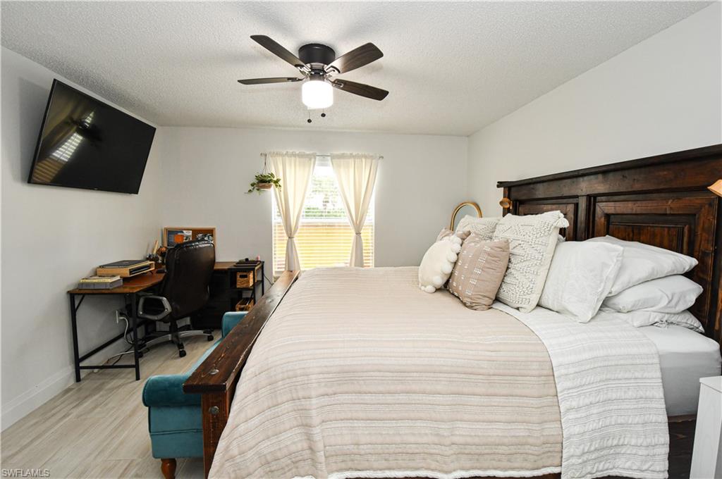 776 Landover Circle, Unit 102 Naples, FL 34104 - Photo 15 of 24 a bedroom with a bed and a flat screen tv