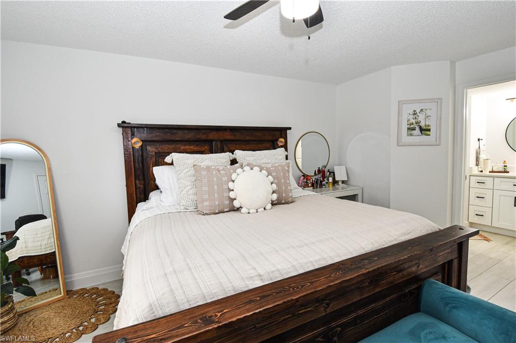 776 Landover Circle, Unit 102 Naples, FL 34104 - Photo 16 of 24 a bedroom with bed and wooden floor