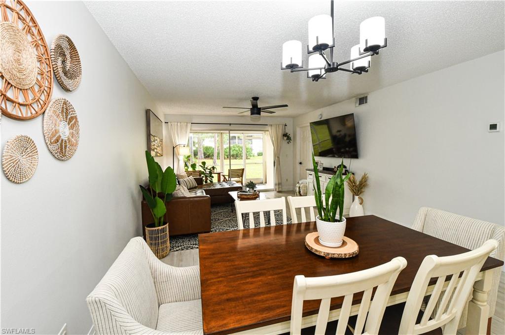 776 Landover Circle, Unit 102 Naples, FL 34104 - Photo 6 of 24 a view of a dining room with furniture a livingroom and chandelier
