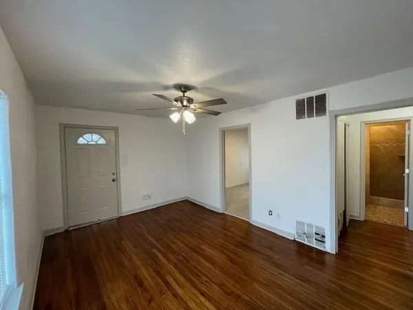 a view of an empty room with wooden floor