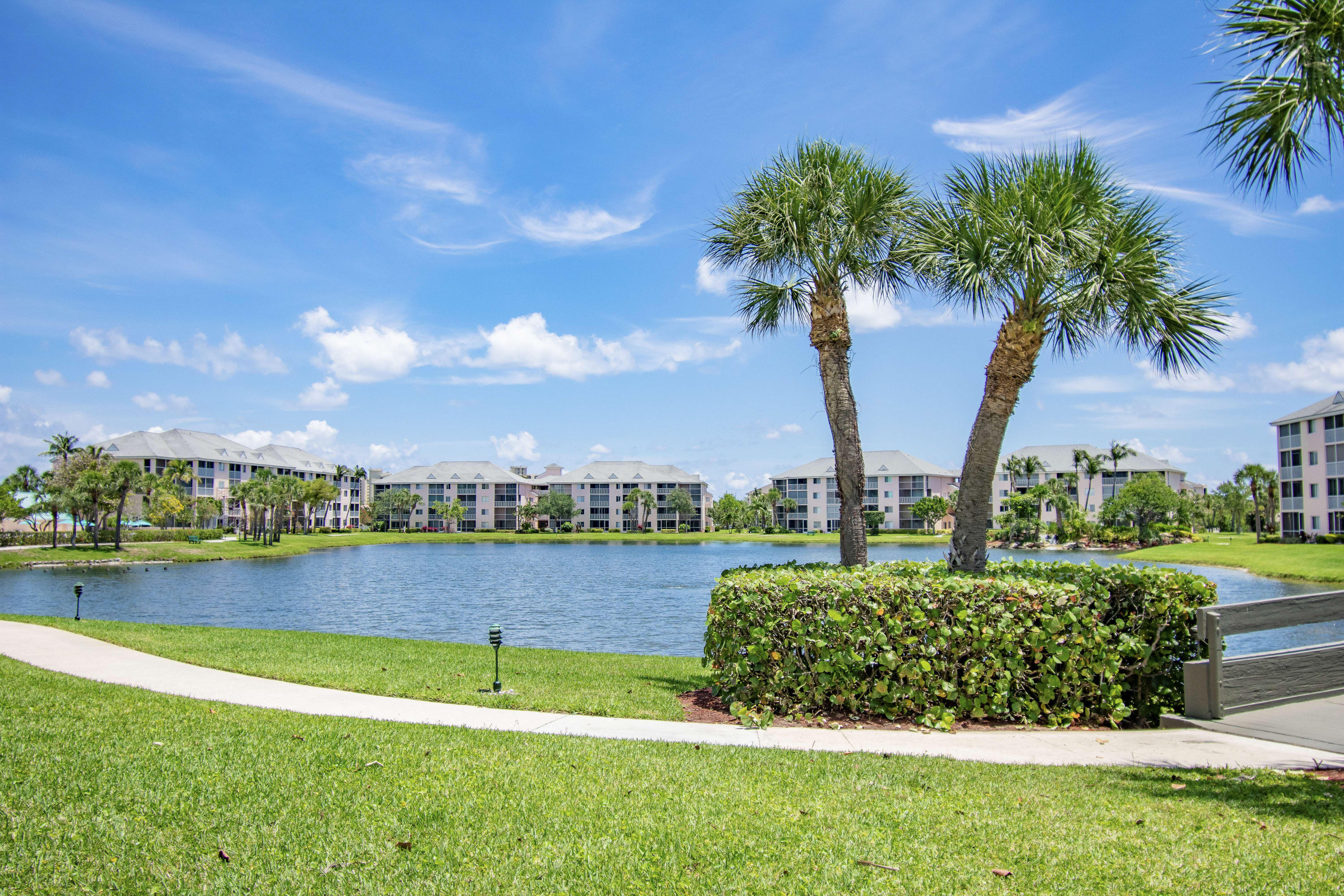 353 Highway 1, Unit F407 Jupiter, FL 33477 - Photo 22 of 30 a view of a lake with a big yard and palm trees
