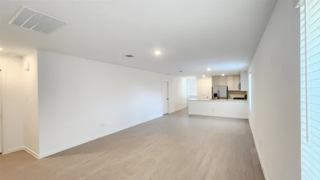 a view of a kitchen with a sink and dishwasher a refrigerator with white cabinets