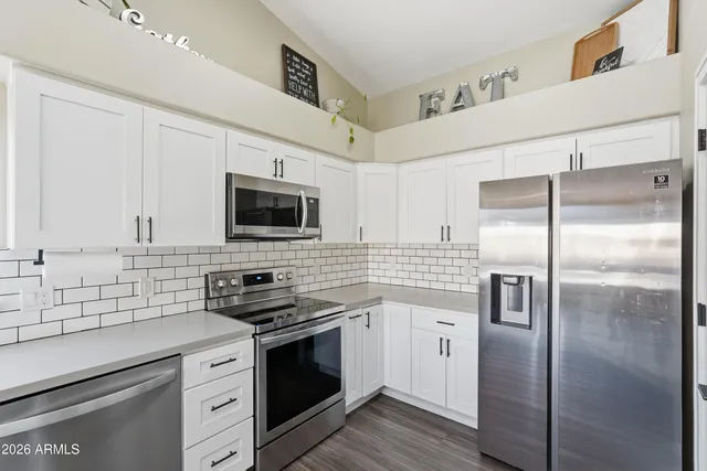 a kitchen with stainless steel appliances a refrigerator and a cabinets
