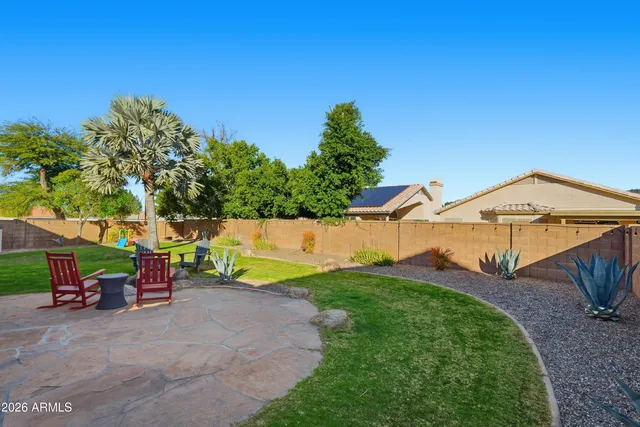 a view of a chairs and table in the back yard of the house