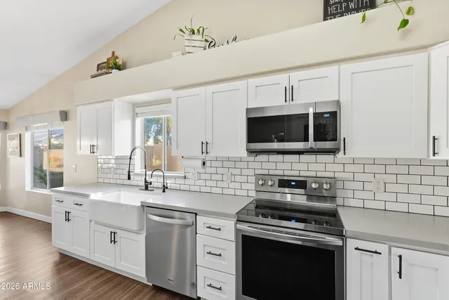 a kitchen with stainless steel appliances a white stove top oven and cabinets