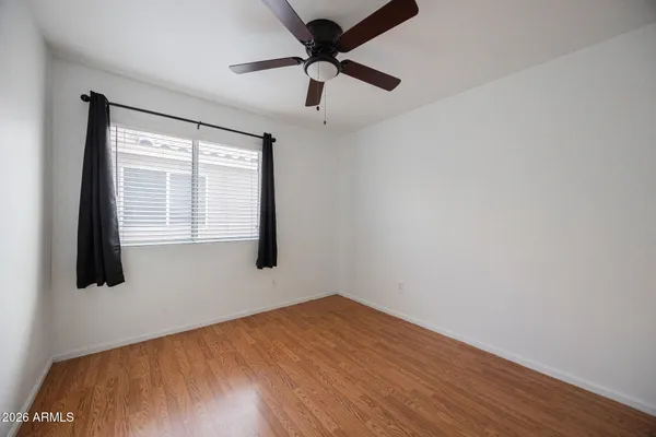 an empty room with a window and a ceiling fan