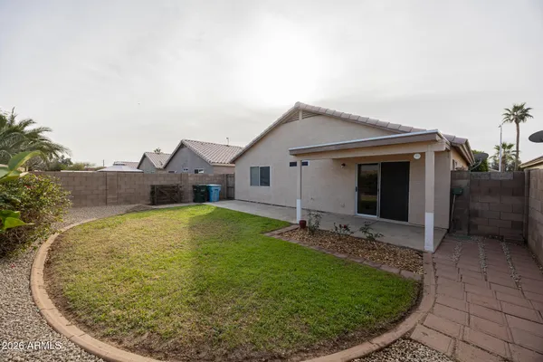 a view of a house with a yard and pathway