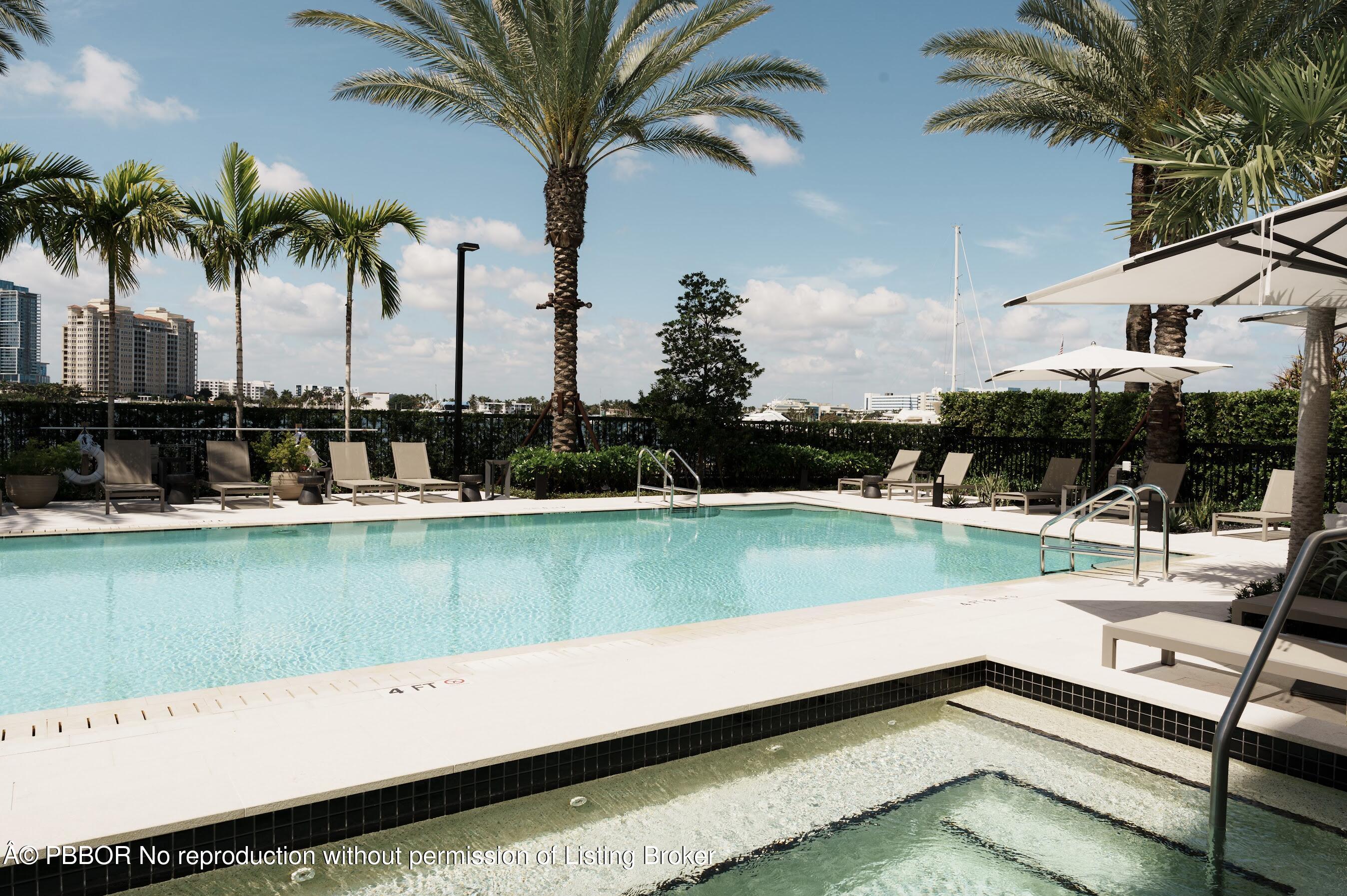 333 Sunset Avenue, Unit 611 Palm Beach, FL 33480 - Photo 23 of 24 a view of a swimming pool with a yard and palm trees