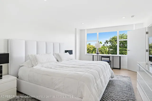 a bedroom with a large bed and a large window