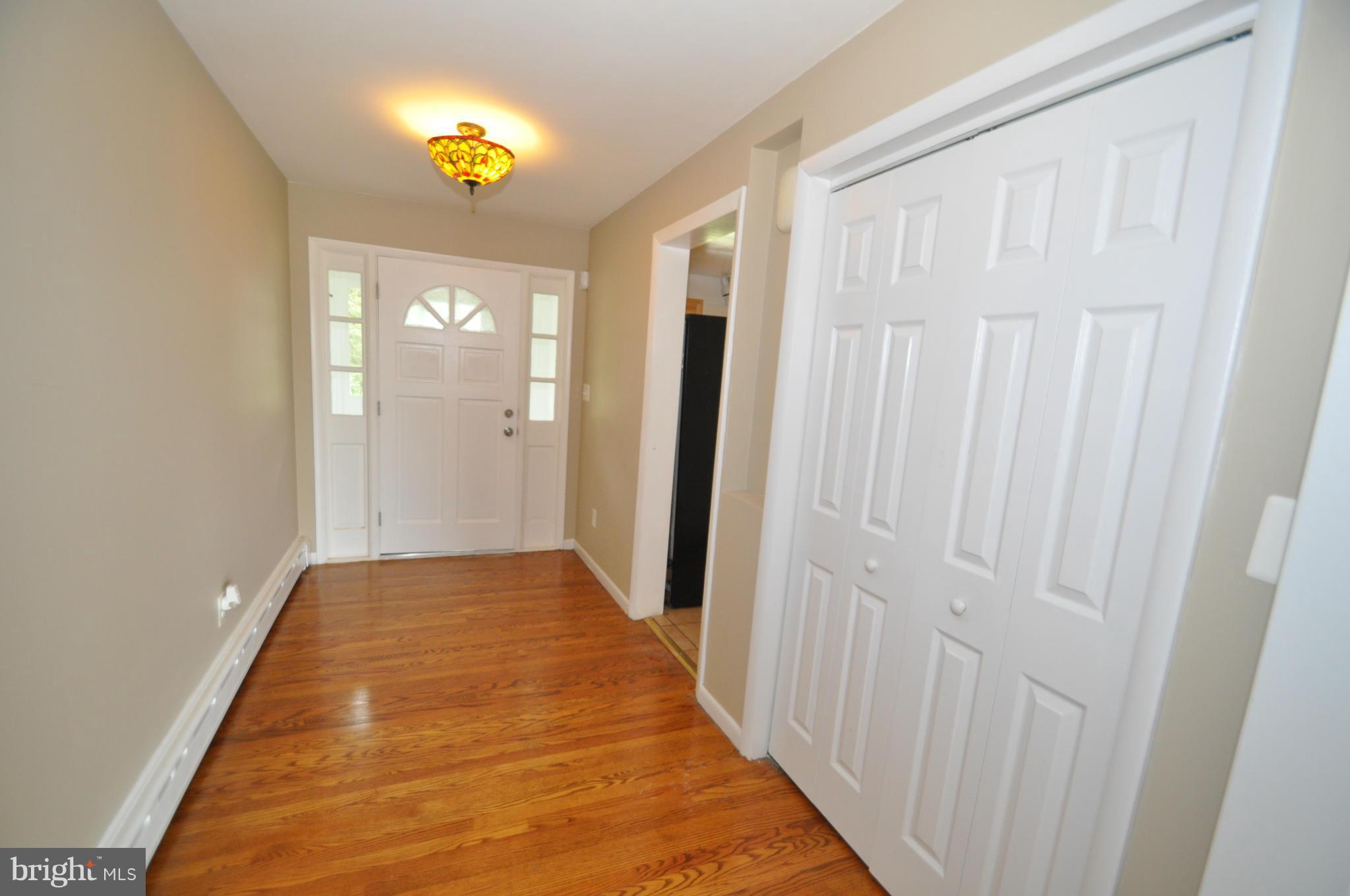 13718 Baldwin Mill Road Baldwin, MD 21013 - Photo 4 of 29 a view of a hallway with wooden floor and a chandelier