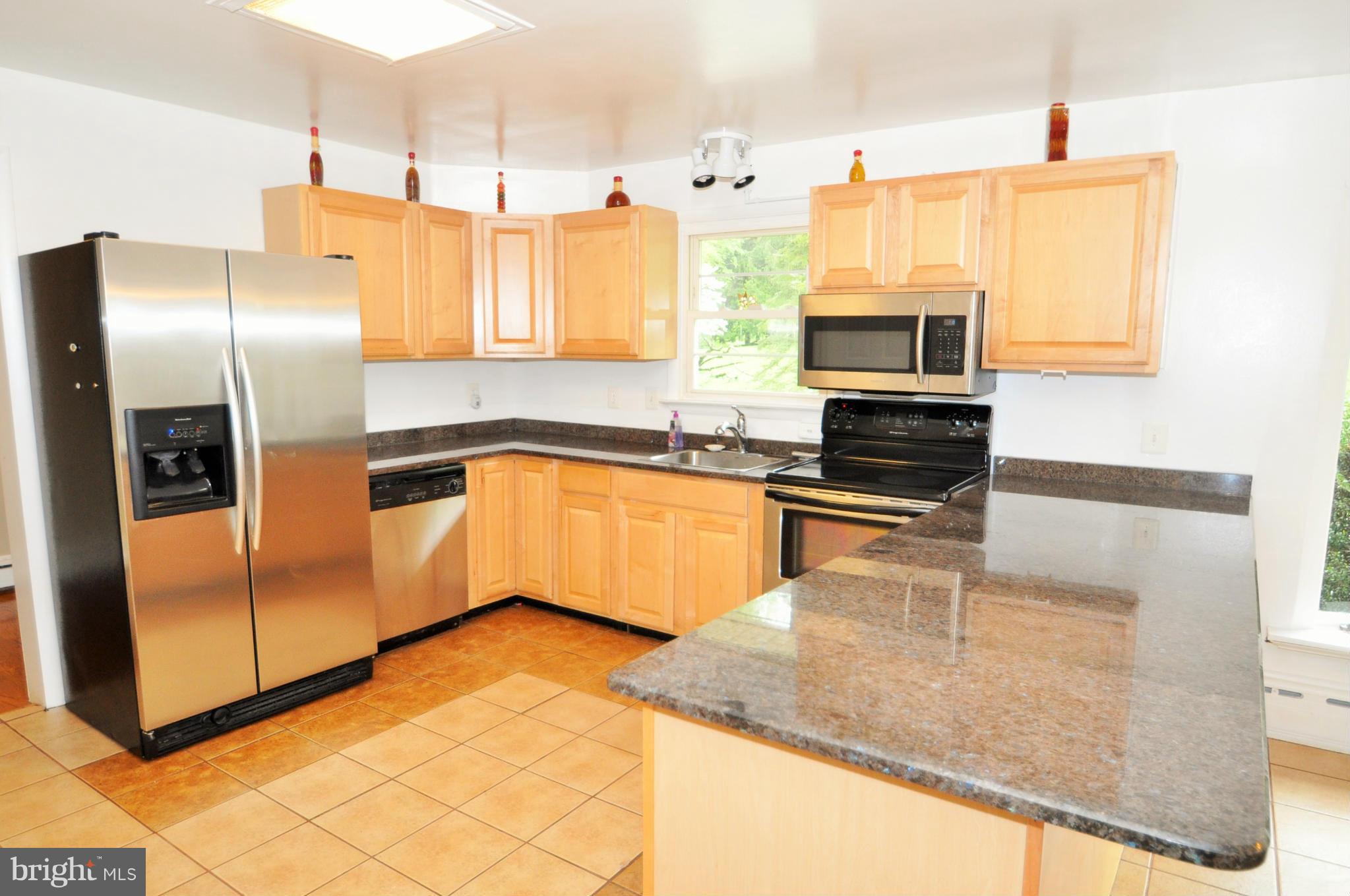 13718 Baldwin Mill Road Baldwin, MD 21013 - Photo 5 of 29 a kitchen with stainless steel appliances granite countertop a sink a stove and a refrigerator