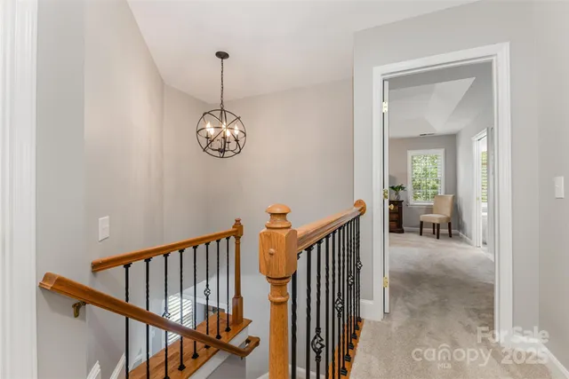 a view of a hallway with wooden floor and stairs