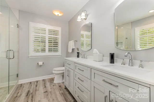 a bathroom with a double vanity sink a toilet and a mirror