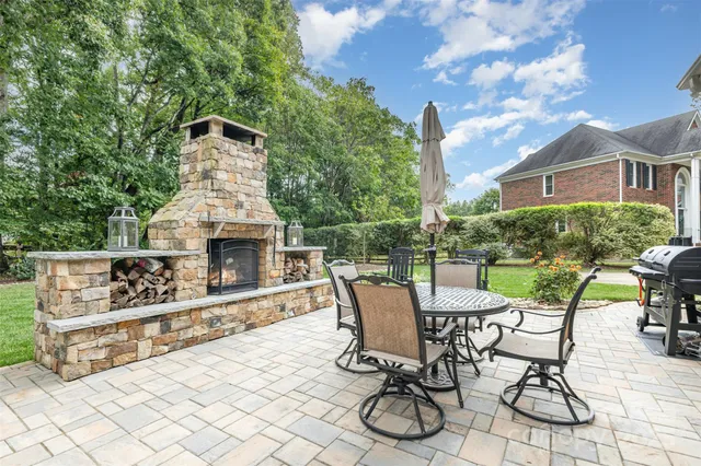 a view of a patio with table and chairs with wooden floor and fence