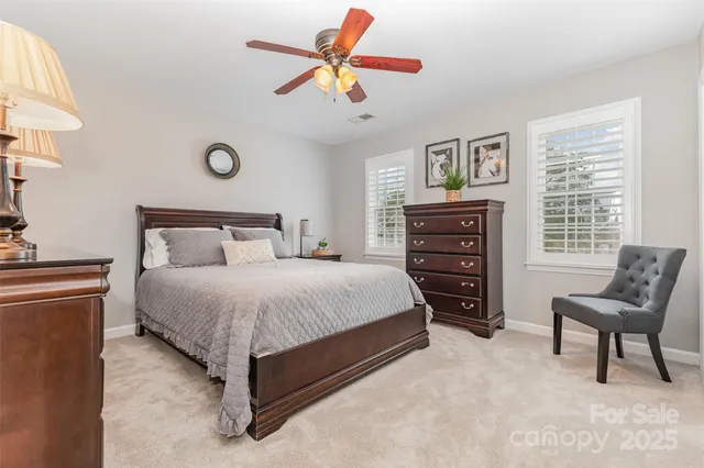 a bedroom with a bed a chandelier and a dresser