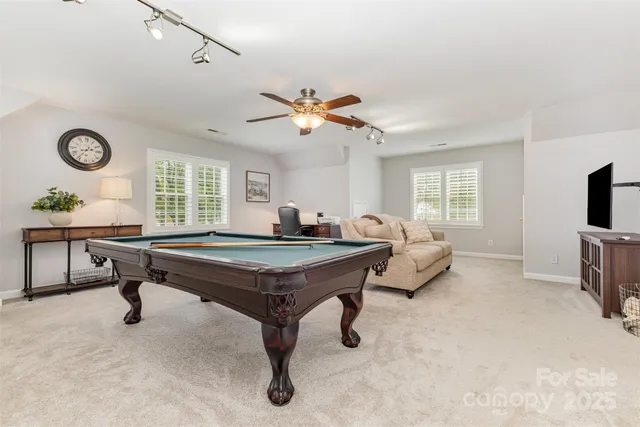 a room with pool table and windows