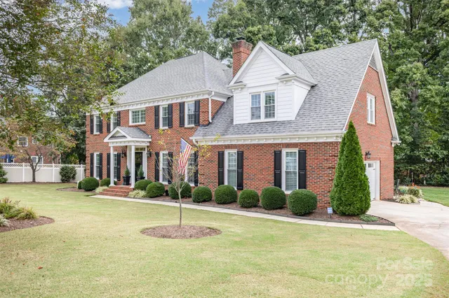 a front view of a house with a yard and trees