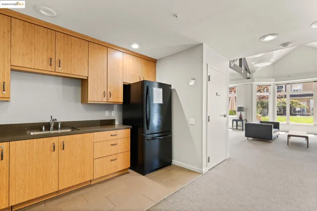 a kitchen with granite countertop a refrigerator and a stove top oven