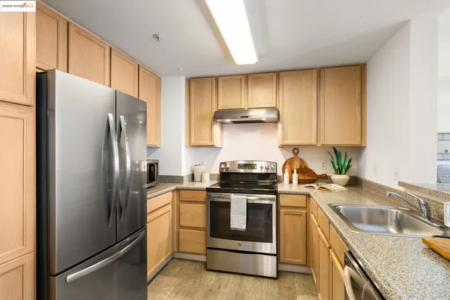 a kitchen with stainless steel appliances granite countertop a stove a refrigerator and a sink
