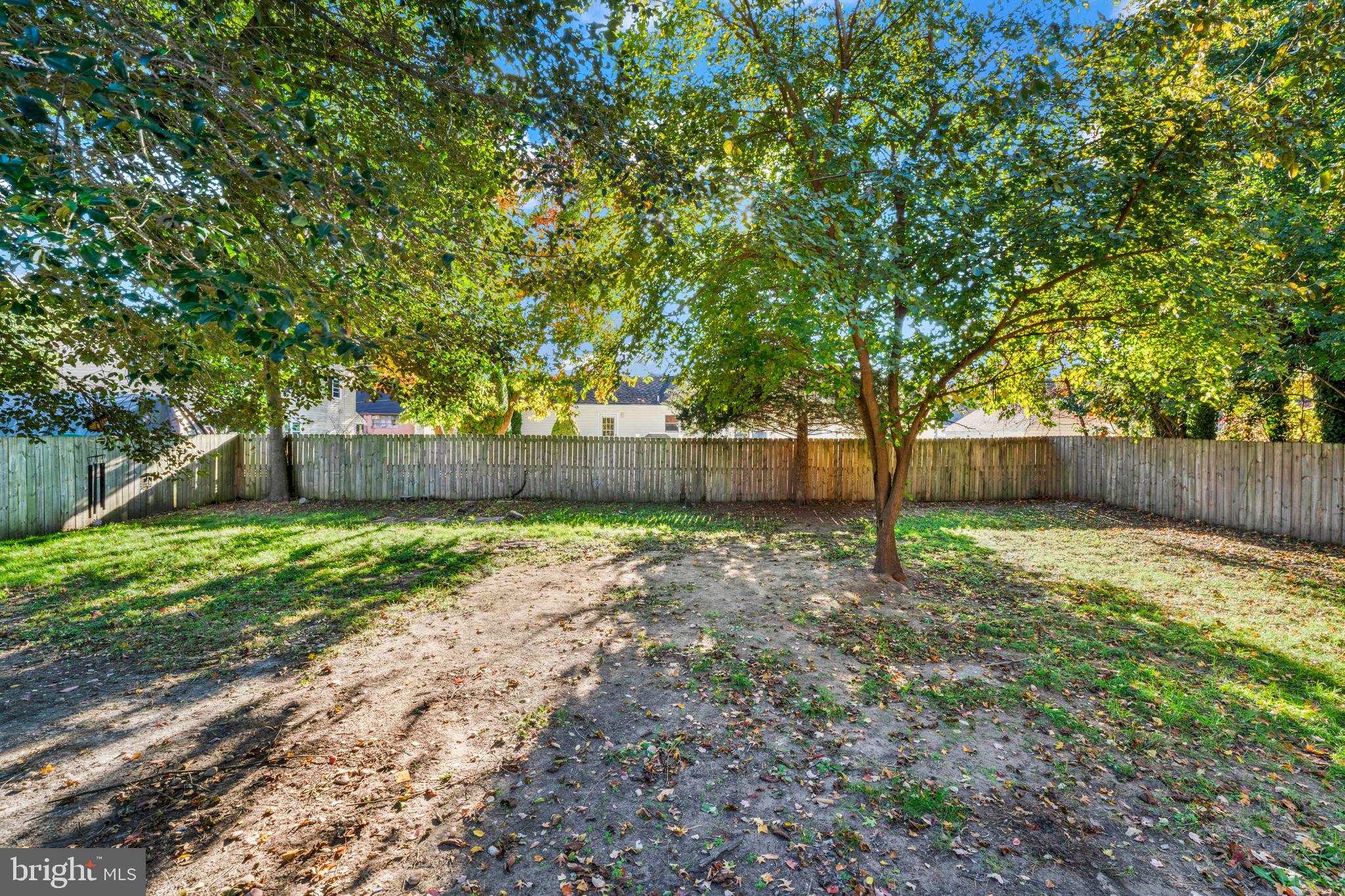 83 Rutgers Road Pennsville, NJ 08070 - Photo 23 of 23 a view of a backyard with large trees and wooden fence