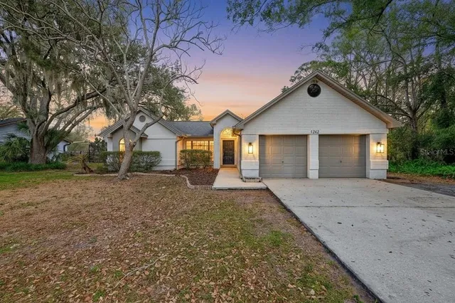 front view of a house with a yard and an trees