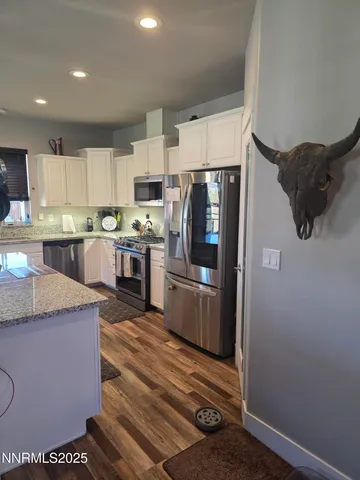 a kitchen with stainless steel appliances granite countertop a refrigerator a stove a sink and a microwave