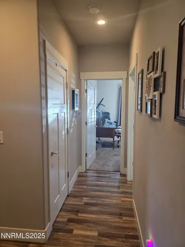 a view of a hallway with wooden floor and closet
