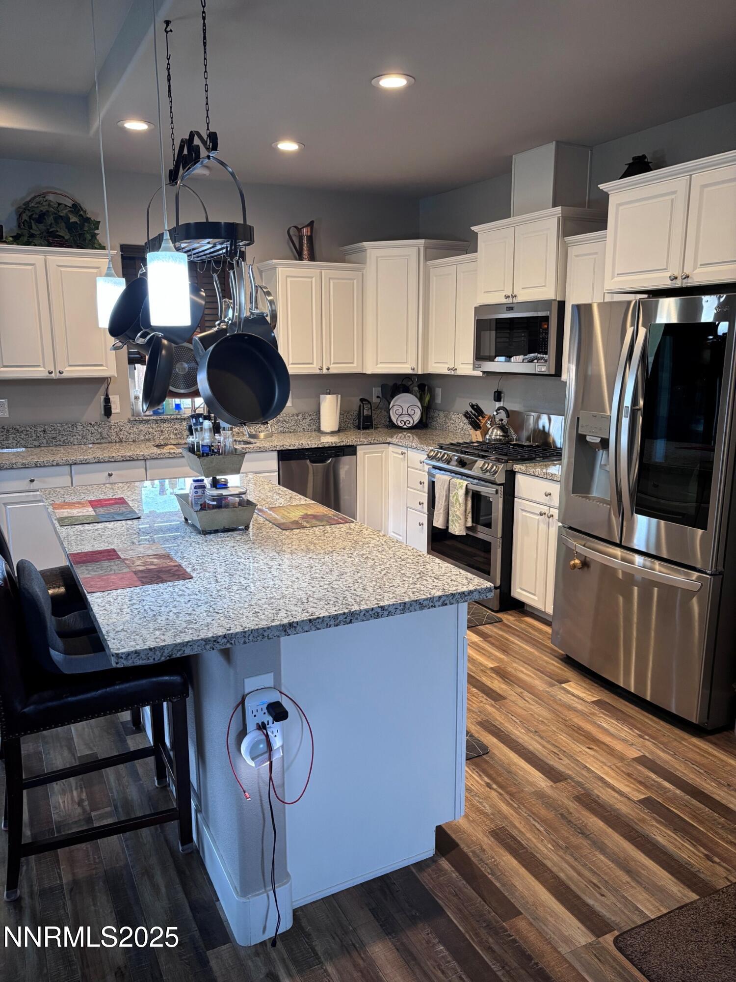 1145 Cheatgrass Drive, Unit BETWEEN DAFFODIL AND ALMOND CREEK Dayton, NV 89403 - Photo 6 of 40 a kitchen with stainless steel appliances granite countertop a sink wooden cabinets and a granite counter tops