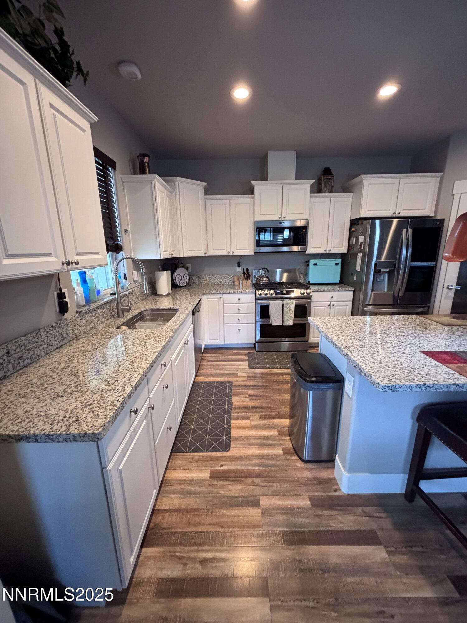1145 Cheatgrass Drive, Unit BETWEEN DAFFODIL AND ALMOND CREEK Dayton, NV 89403 - Photo 7 of 40 a kitchen with stainless steel appliances granite countertop a sink stove and refrigerator