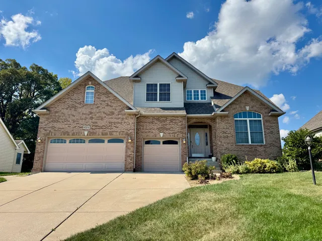 a front view of a house with a yard and garage