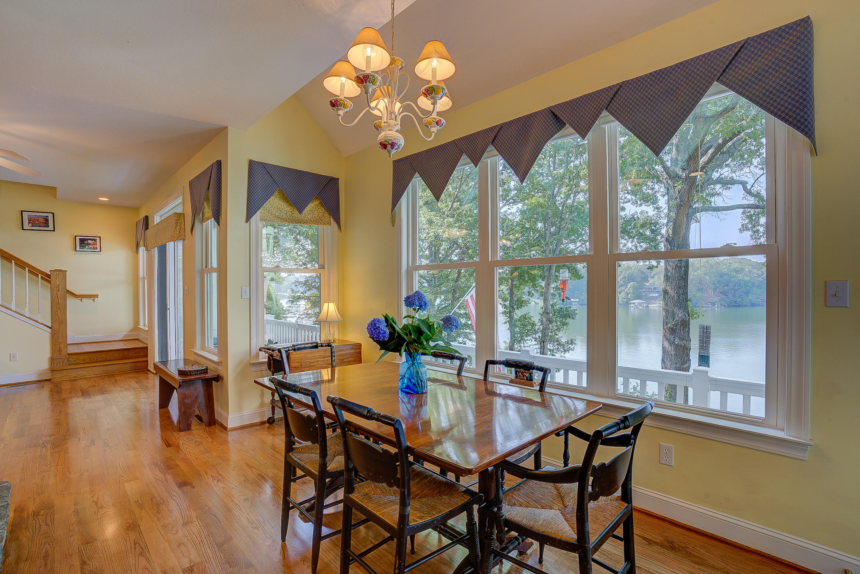 6835 Horseshoe Bend Road Goodview, VA 24095 - Photo 14 of 59 a dining room with wooden floor a chandelier a wooden table and chairs