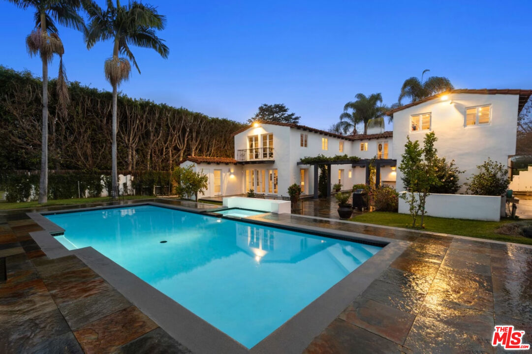 710 Walden Drive Beverly Hills, CA 90210 - Photo 3 of 20 a view of a swimming pool with a yard and palm trees