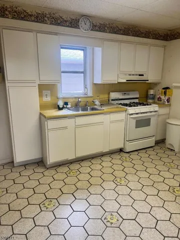a kitchen with granite countertop white cabinets and white appliances