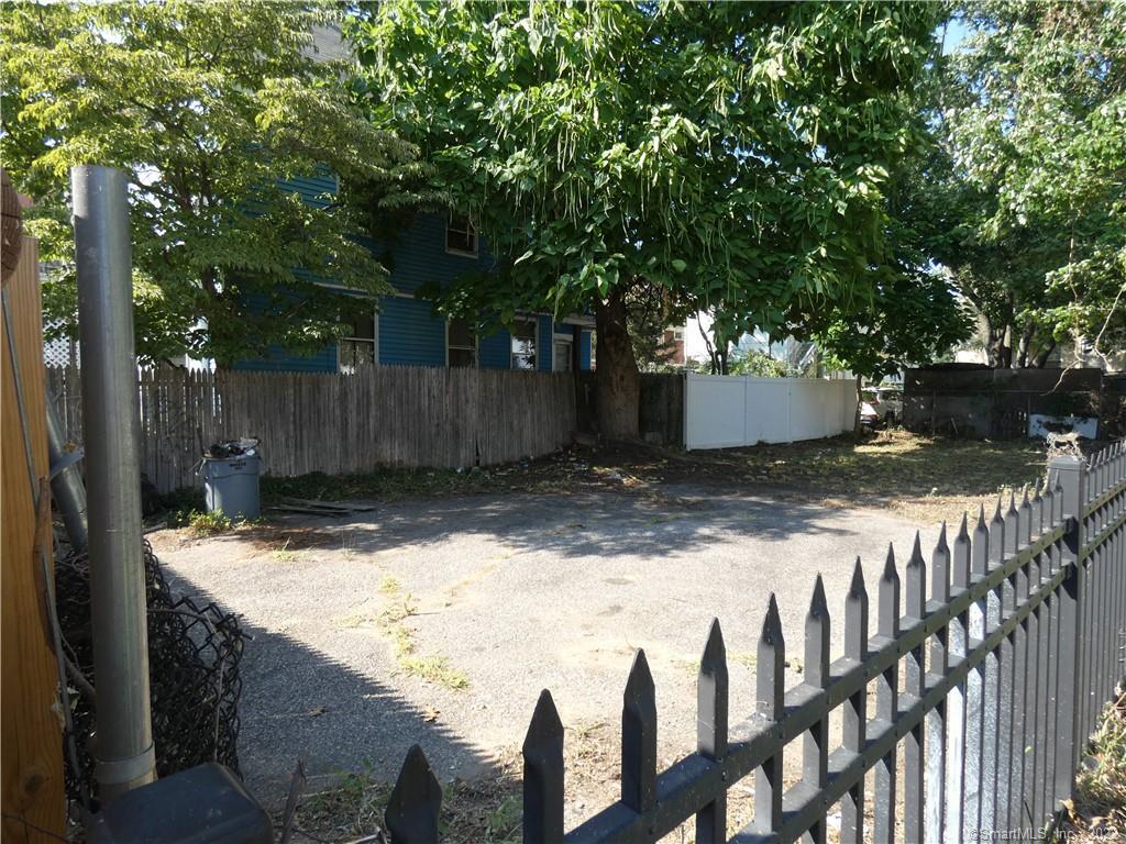 a view of backyard with wooden fence