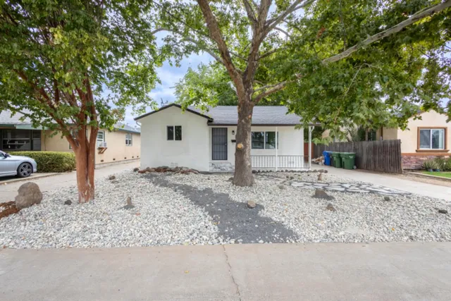 a white house that has a tree in front of it