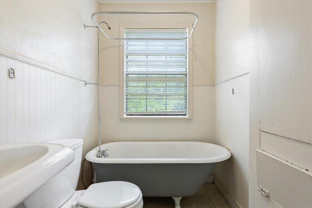 608 9th Street Hico, TX 76457 - Photo 12 of 23 Clawfoot tub with shower assembly and window with blinds