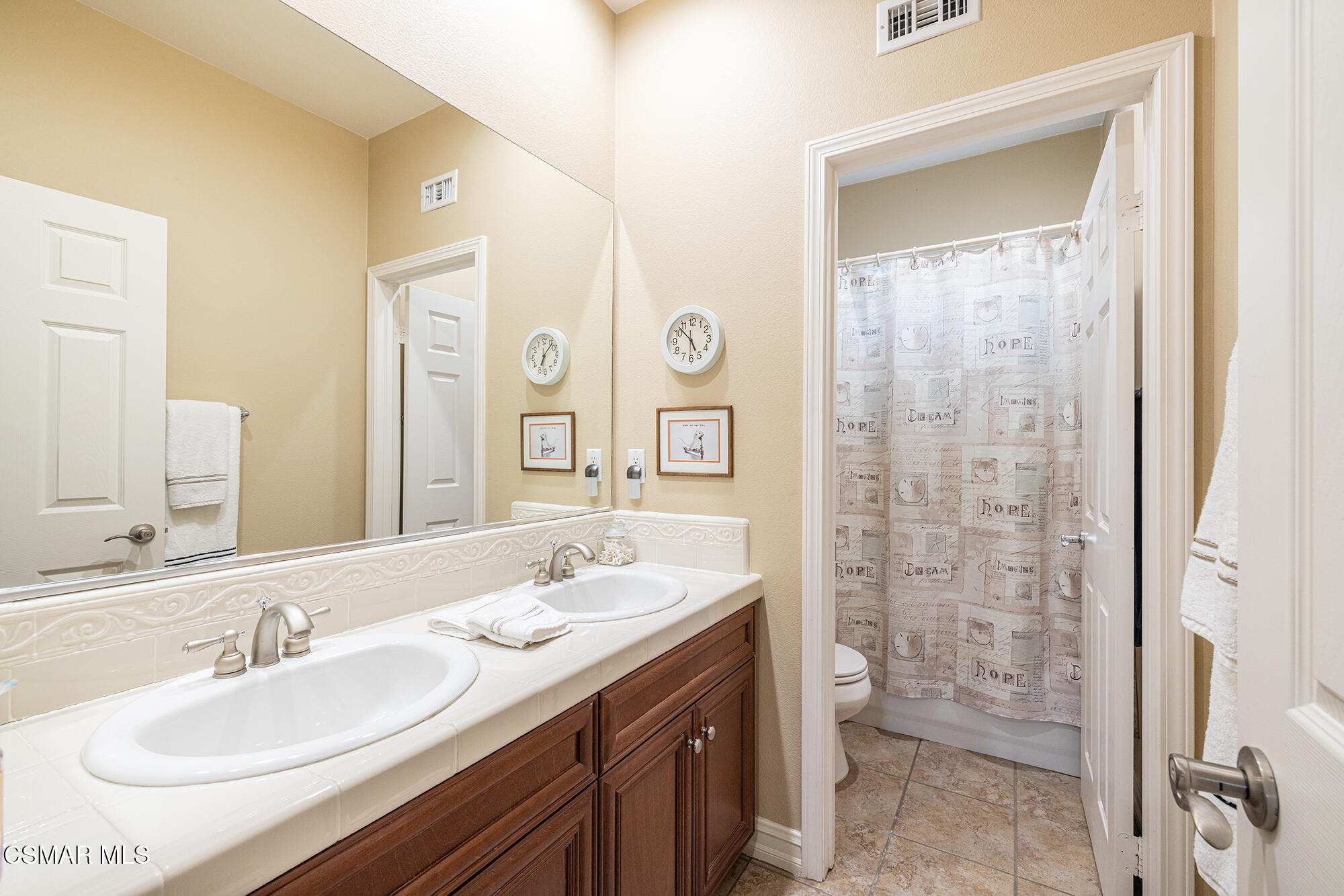 5019 Corral Street Simi Valley, CA 93063 - Photo 24 of 50 a bathroom with a double vanity sink toilet and a mirror