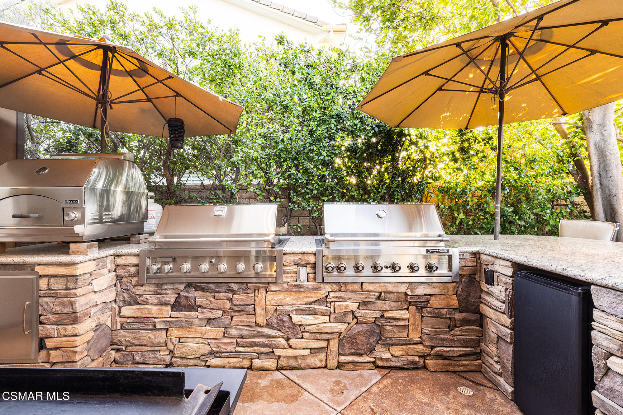 5019 Corral Street Simi Valley, CA 93063 - Photo 34 of 50 a view of a patio with table and chairs under an umbrella