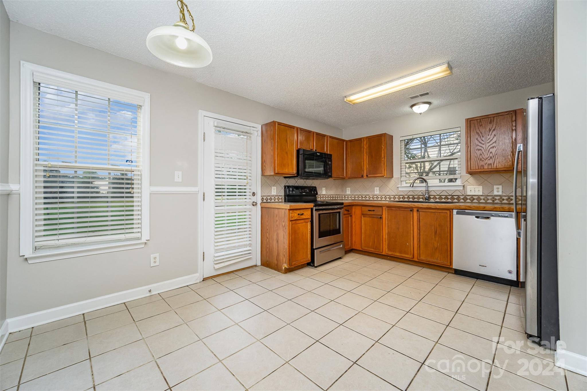 5018 Revelation Way Monroe, NC 28110 - Photo 7 of 19 a kitchen with stainless steel appliances granite countertop a stove sink and cabinets