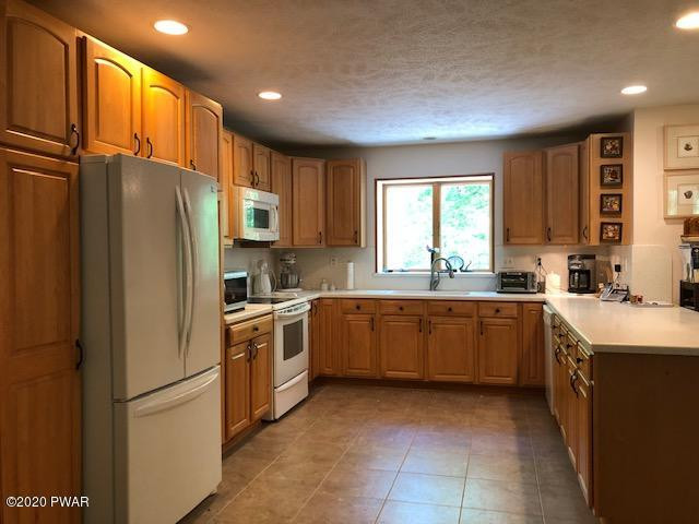 116 Maple Ridge Drive Hawley, PA 18428 - Photo 5 of 19 a kitchen with a refrigerator sink and cabinets