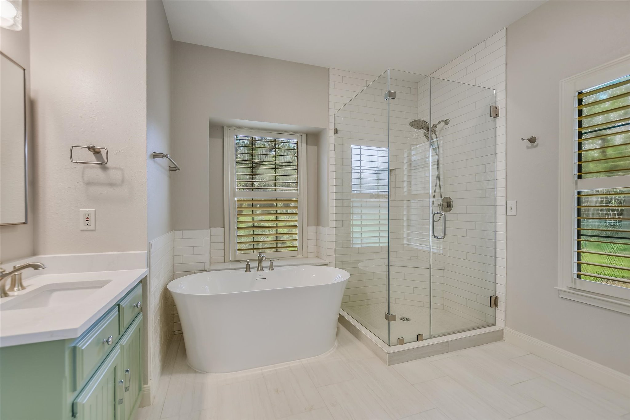 328 Fawnridge Street Georgetown, TX 78628 - Photo 16 of 33 Newly renovated, spa-like primary bathroom, featuring quartz vanities, new tile flooring, tiled shower with frameless glass, new soaking tub, and updated fixtures, mirrors, hardware and lighting!