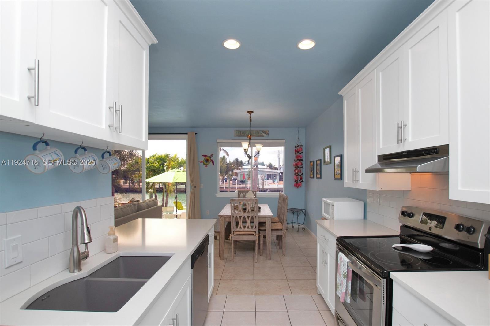 461 3rd Street Key Colony Beach, FL 33051 - Photo 18 of 79 a kitchen with kitchen island granite countertop a sink and a stove top oven