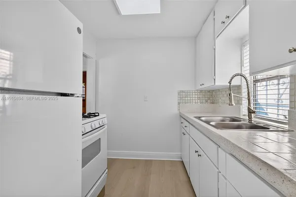 a kitchen with granite countertop a sink stove and cabinets