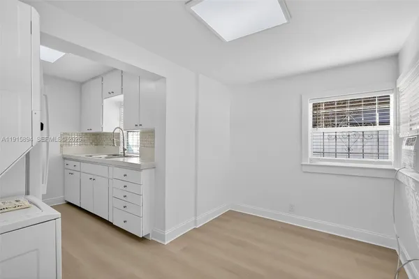 a room with white cabinets and sink
