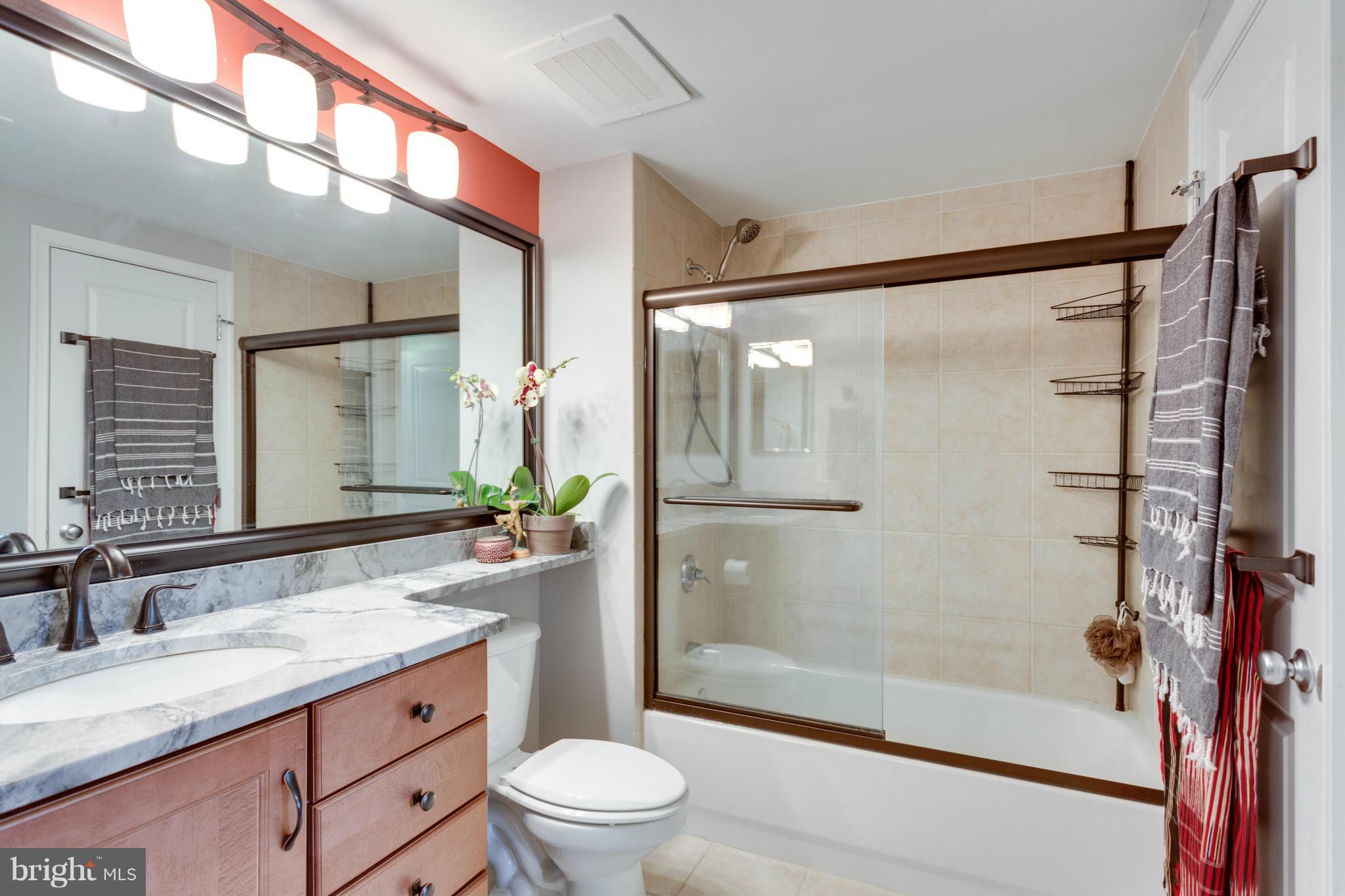 851 North Glebe Road, Unit 501 Arlington, VA 22203 - Photo 18 of 30 a bathroom with a granite countertop sink toilet and shower
