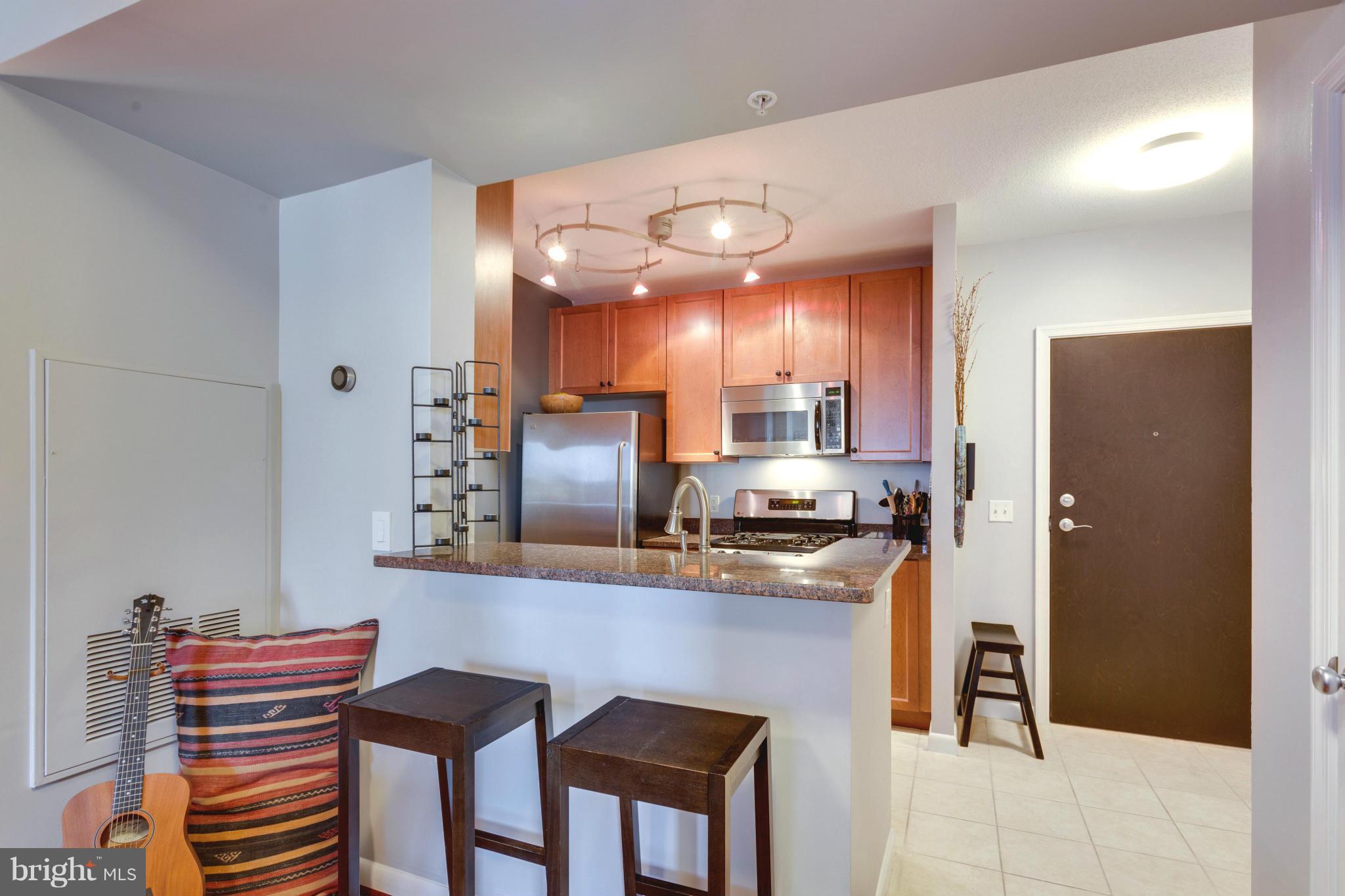851 North Glebe Road, Unit 501 Arlington, VA 22203 - Photo 8 of 30 a kitchen with stainless steel appliances a sink stove and refrigerator